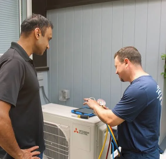 Homeowner speaking with an HVAC technician during an outdoor system check